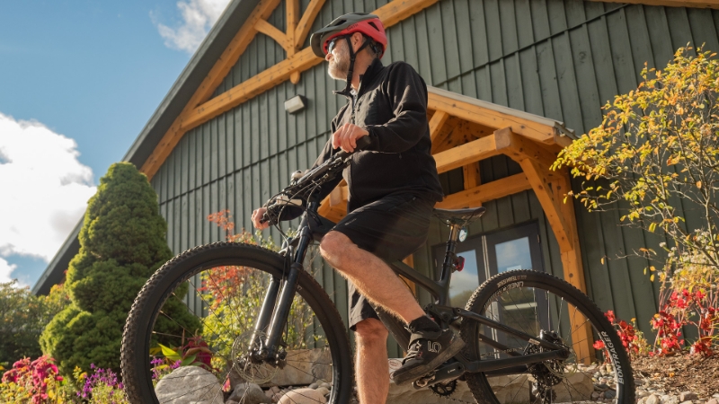 Man on a mountain bike outside of a wooden building