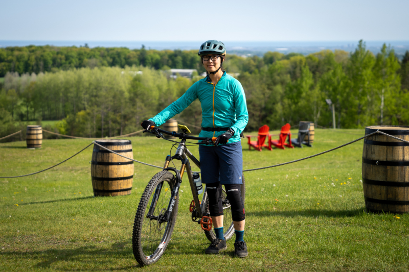Woman in mountain biking gear holding her bike.